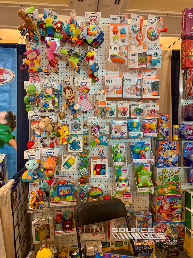 Custom retail display wall featuring colorful toys arranged on pegboard merchandising systems inside an exhibit booth.