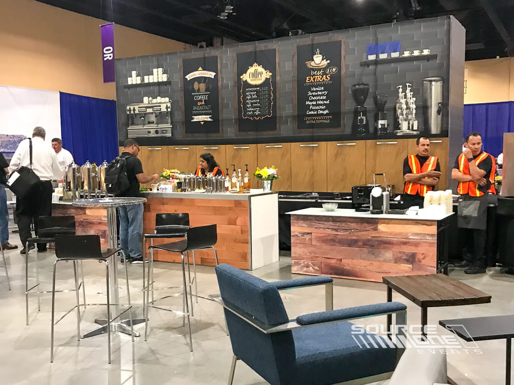 Large healthcare trade show exhibit featuring wood finishes, illuminated branding, product displays, and comfortable meeting areas.