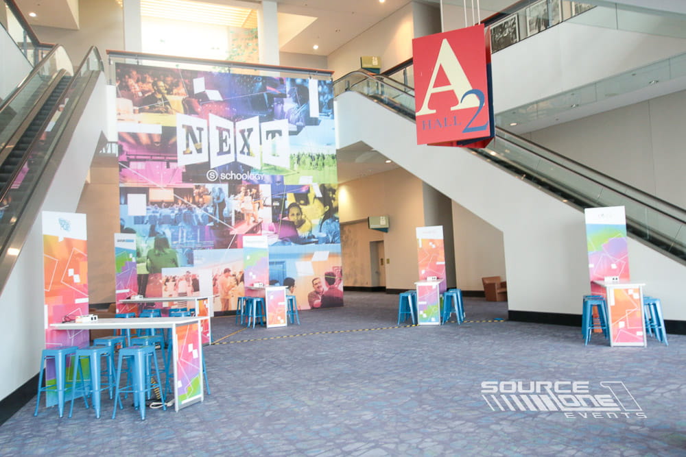 Custom conference lounge featuring colorful environmental graphics, branded architecture, casual seating, and attendee networking space.