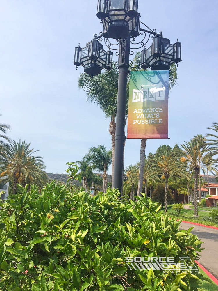 Overhead lobby banner featuring sponsor branding and directional messaging above the convention entrance corridor.