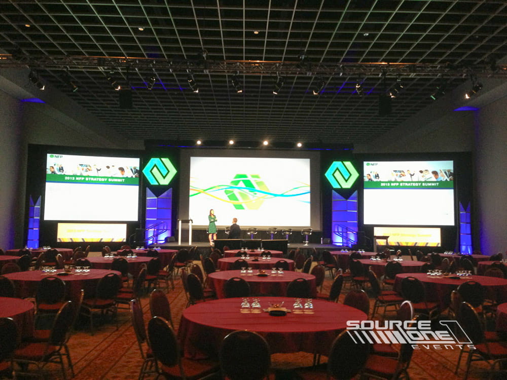 General session stage featuring LED screens, conference branding, and professional stage production within a large ballroom.