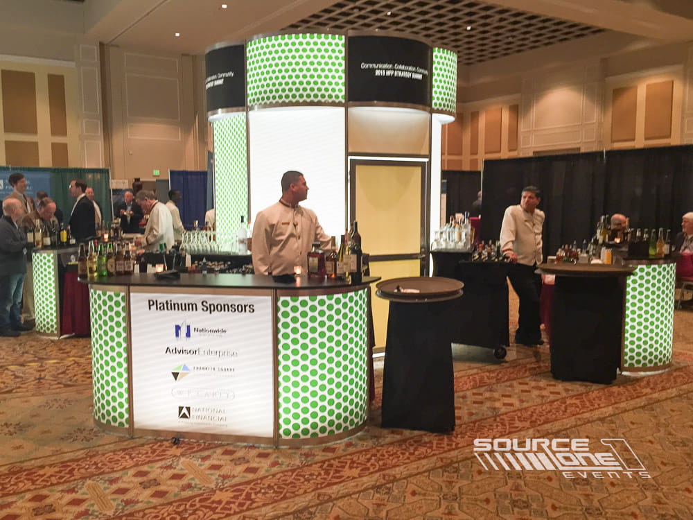 Custom hospitality bar with branded tower display creating a networking space for conference attendees.