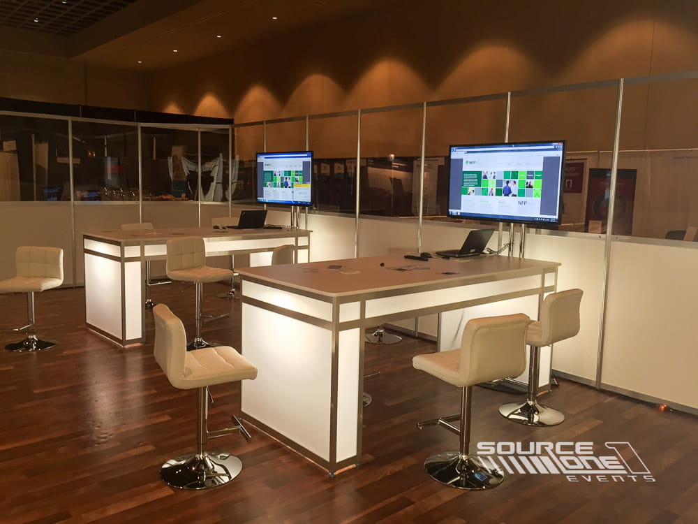 Open networking café with high-top tables, wood finishes, and comfortable attendee meeting areas.