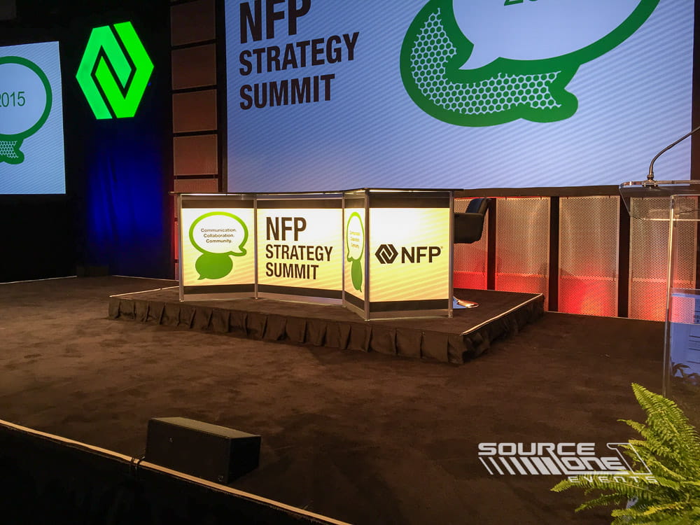 Custom branded stage counter and presentation area for the NFP Strategy Summit conference.