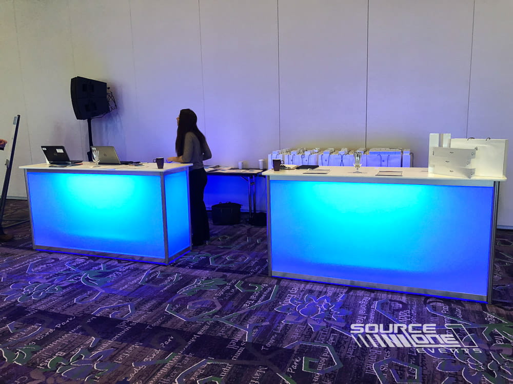 Illuminated backlit counters creating a modern registration and hospitality experience.