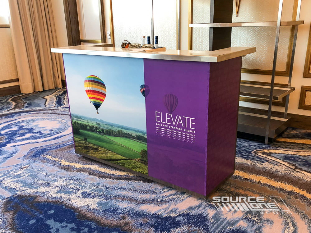 Custom branded reception counter for attendee check-in and event information.