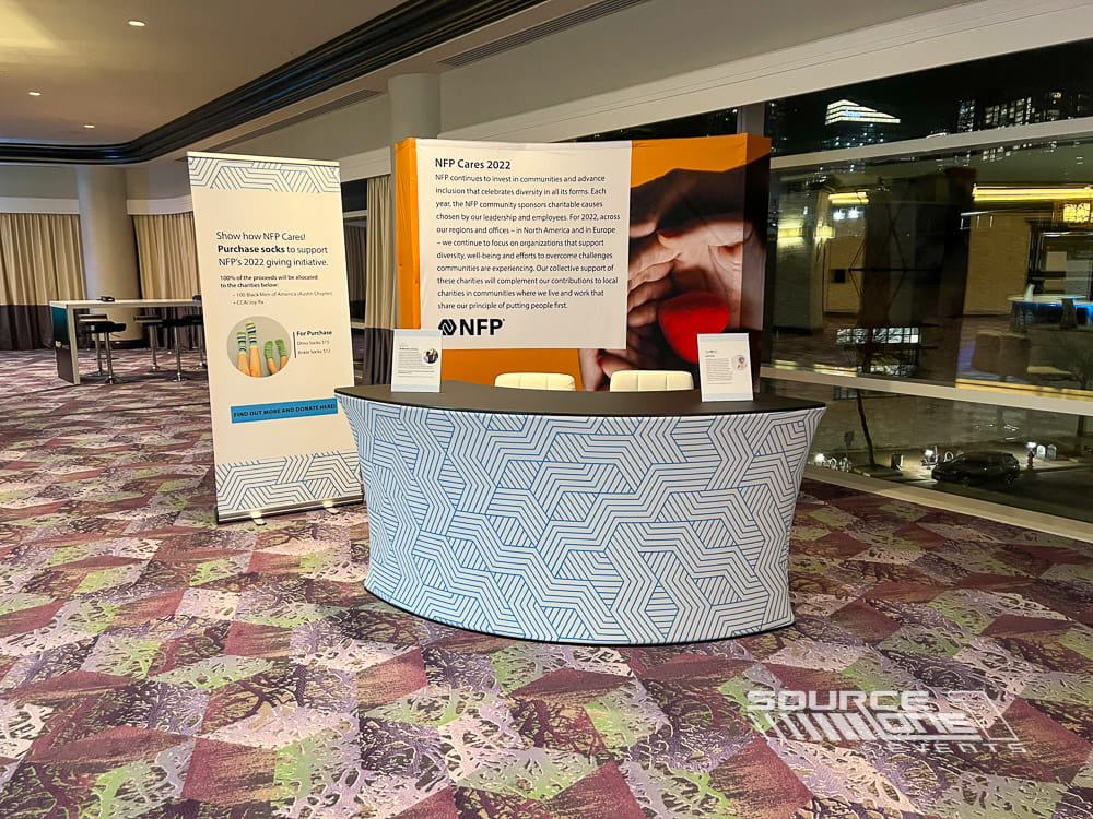 Custom back wall and information counter supporting a charity activation at an event.