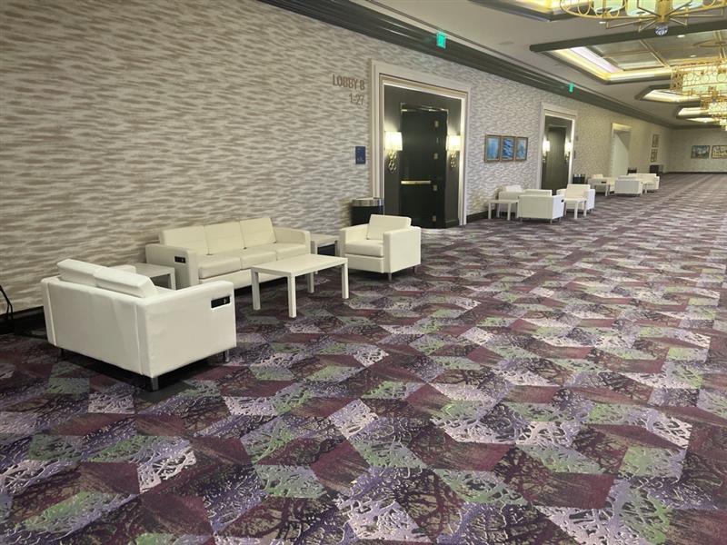 White hospitality furniture setup in convention center pre-function space