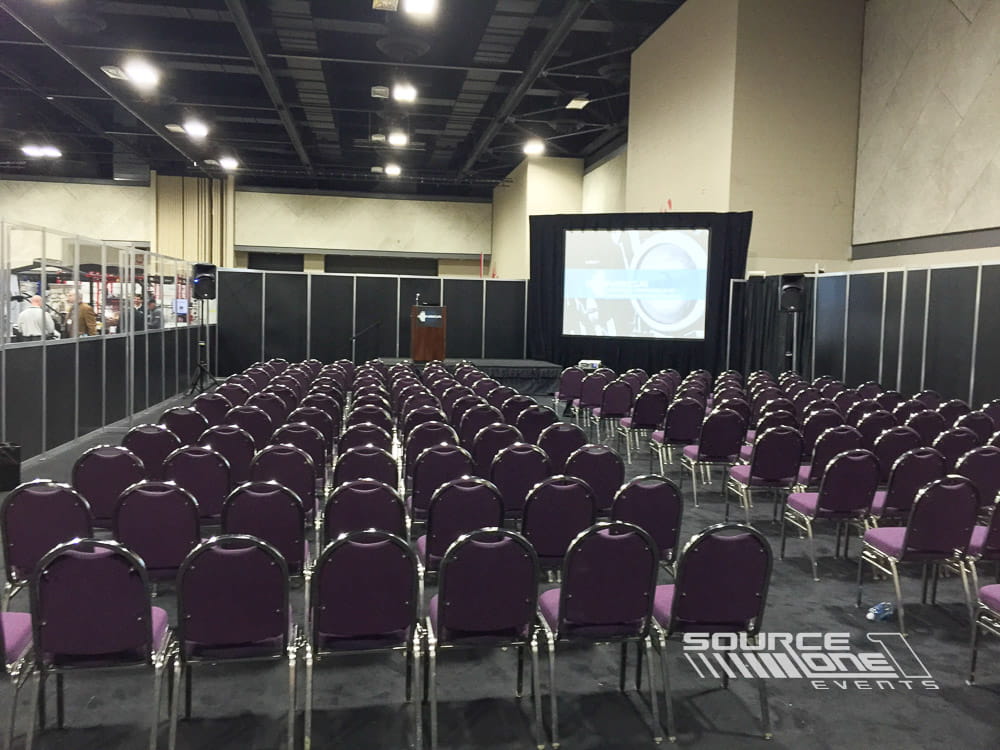 Professional seminar stage featuring theater seating, large presentation screen, and conference education environment.
