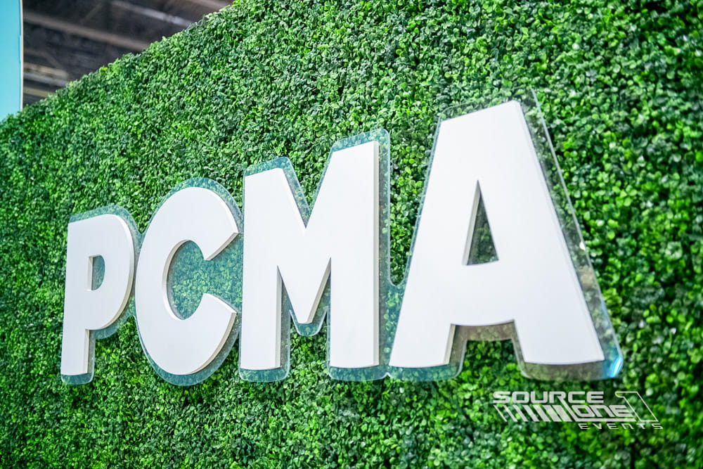 Large illuminated PCMA logo letters displayed as a conference centerpiece.