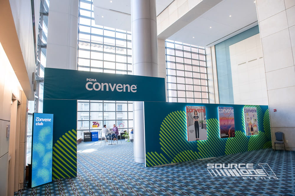 Modern Convene Club networking lounge featuring teal branding, digital displays, and open attendee collaboration space at PCMA Convening Leaders.