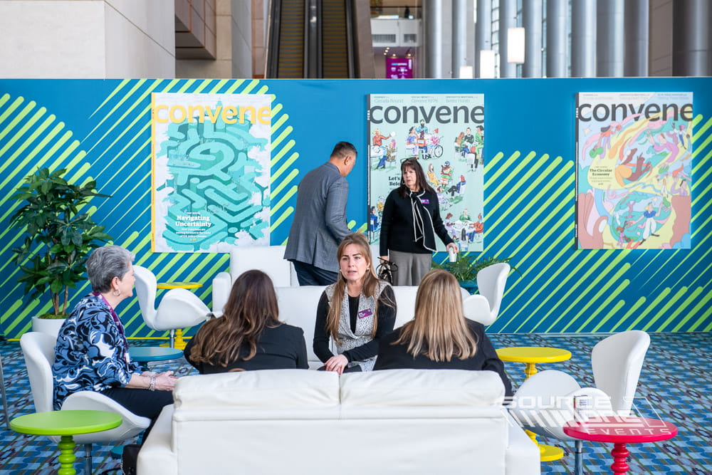 Branded networking club with vibrant environmental graphics, attendee seating, and collaborative meeting spaces designed for PCMA Convening Leaders.
