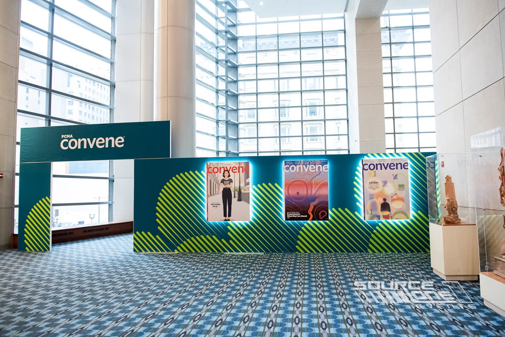 Custom branded Convene Club activation with illuminated graphics, magazine displays, lounge seating, and experiential networking space.