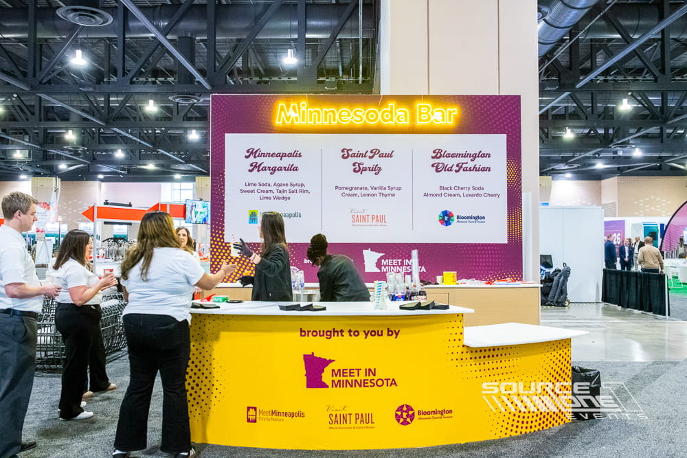Custom hospitality activation featuring a branded dirty soda bar with colorful graphics, illuminated signage, and beverage service for attendee engagement.