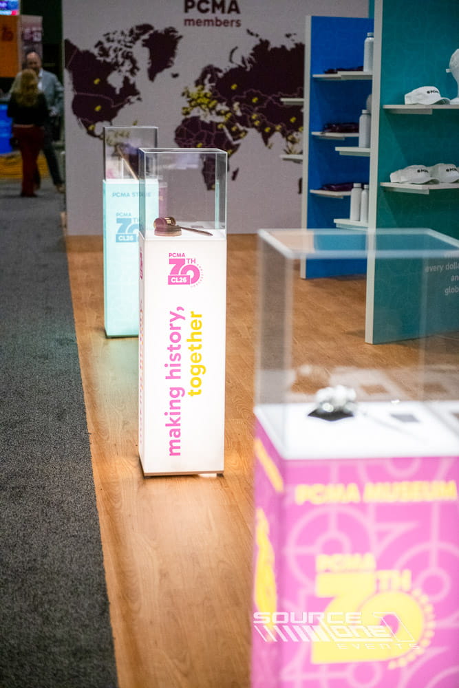 Custom glass display cases with integrated lighting highlighting featured exhibits within a conference experience.