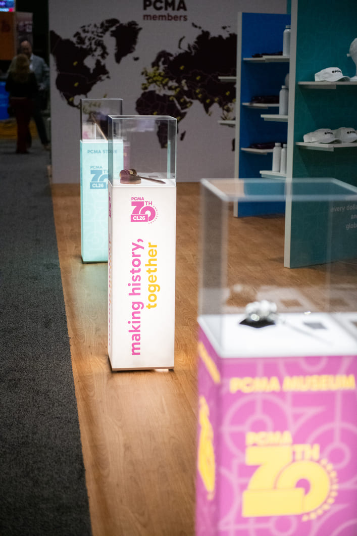 Branded magazine lounge featuring conference publications and attendee seating.