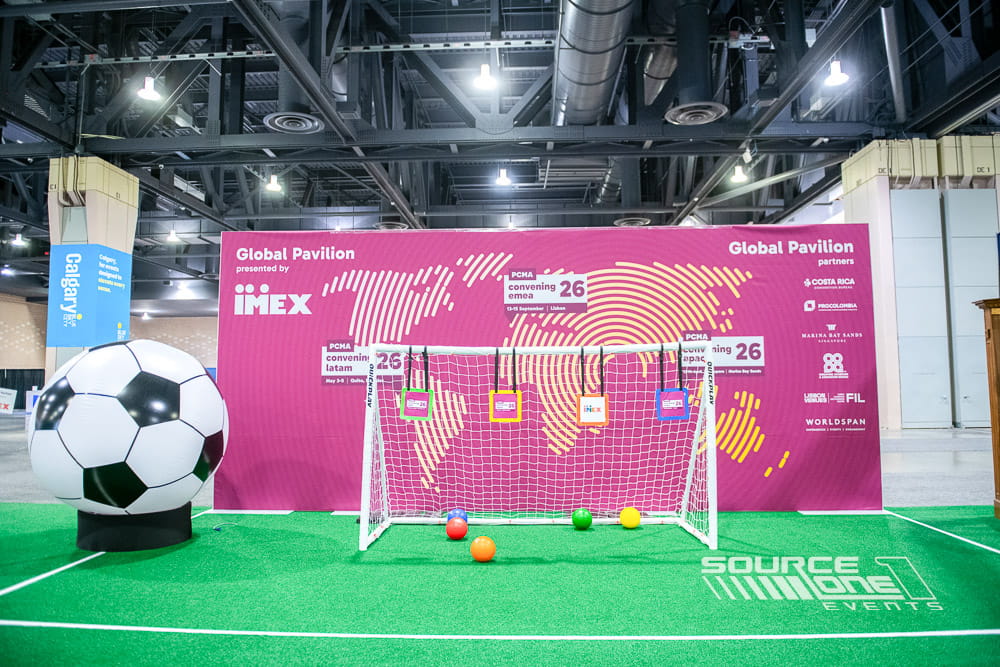 Large international pavilion featuring colorful environmental graphics, country branding, and exhibitor displays designed for attendee exploration and networking.