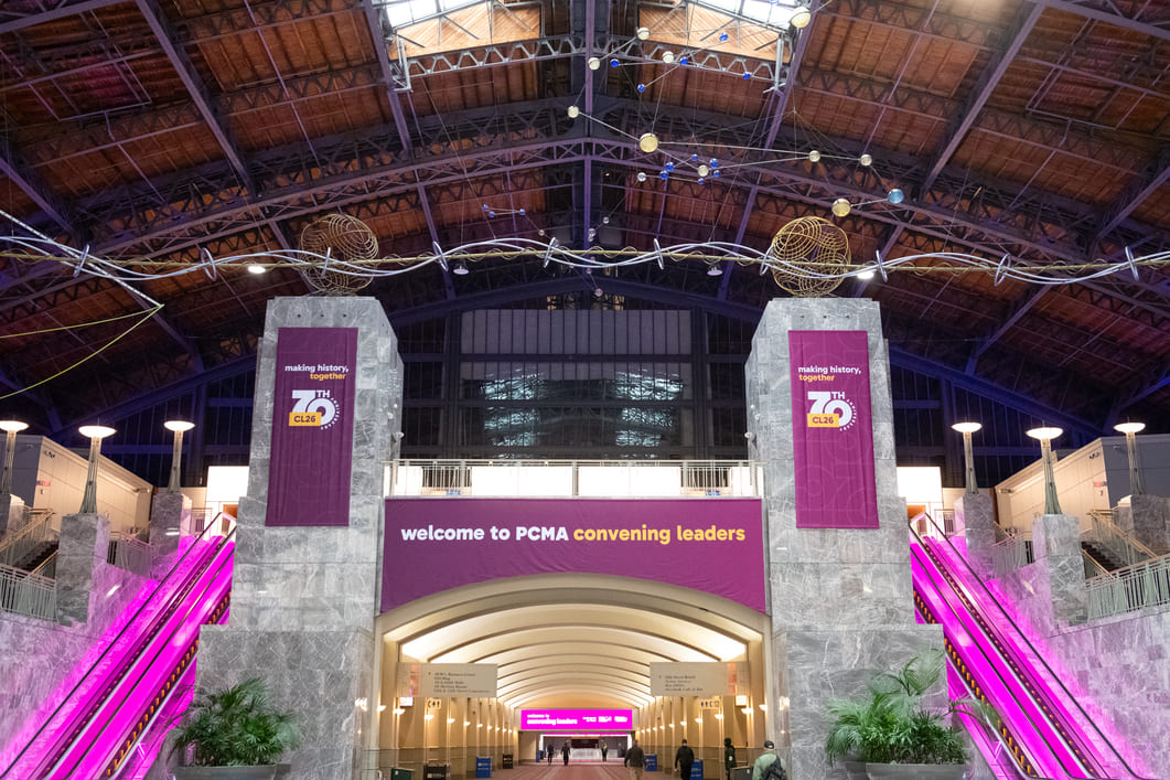 Convention center entrance featuring custom event branding, illuminated escalators, and welcome signage for the PCMA Convening Leaders conference.