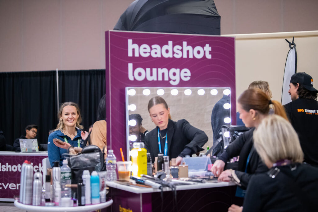 Conference attendees visiting a branded headshot lounge for complimentary professional portraits.