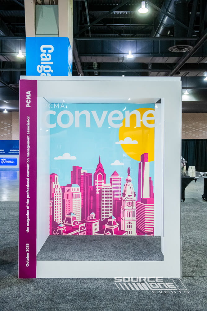 Custom magazine lounge featuring colorful PCMA Convene branding, illuminated environmental graphics, and attendee reading space.