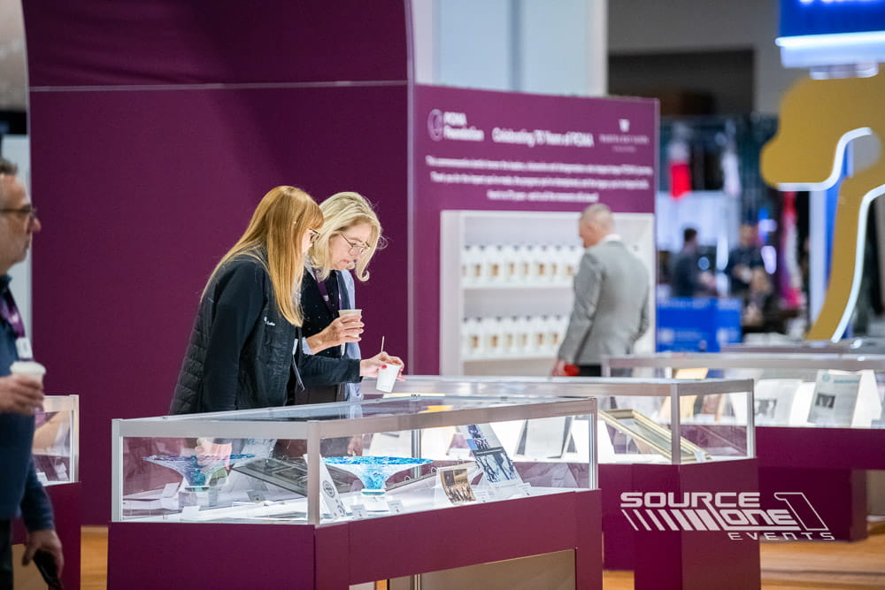 Museum-quality exhibit display featuring glass cases and educational artifacts produced by Source One Events for PCMA Convening Leaders.