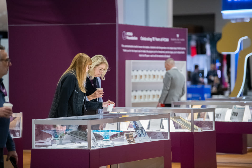 Conference attendee viewing products inside a branded museum-style exhibit.