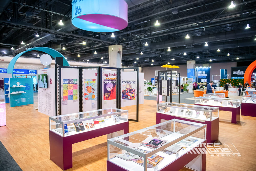 Retail-style merchandise and museum experience with branded graphics, display cases, and interactive exhibits inside the convention hall.