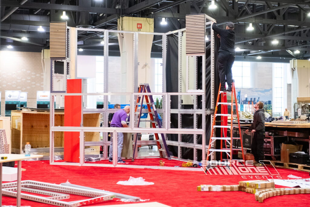 Installation crew assembling a custom trade show exhibit structure.