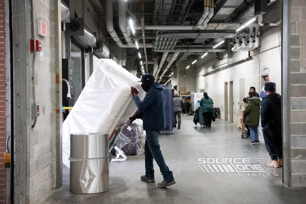 Team members positioning exhibit materials during convention setup.