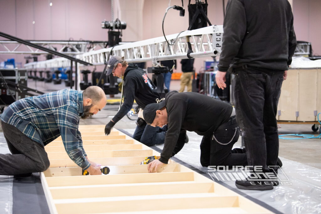 Installation crew preparing exhibit components during conference setup.