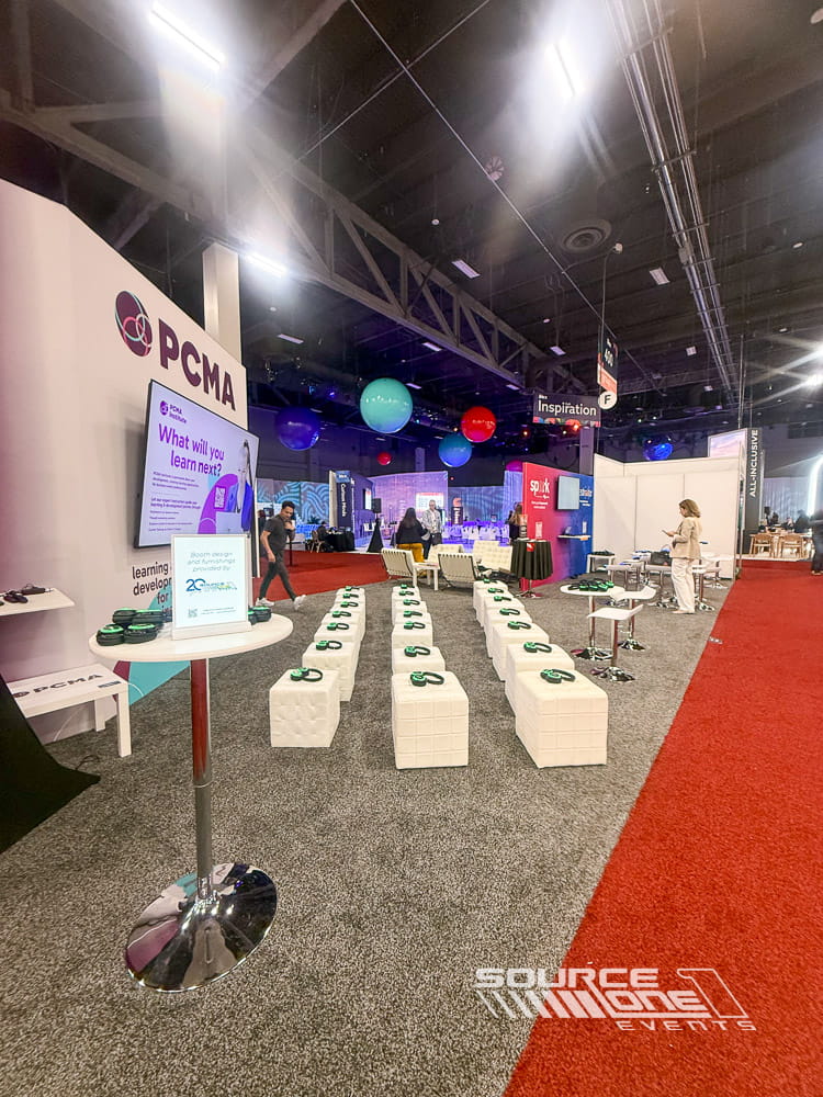 Modern custom trade show booth featuring vibrant environmental graphics, meeting tables, and open attendee engagement areas.