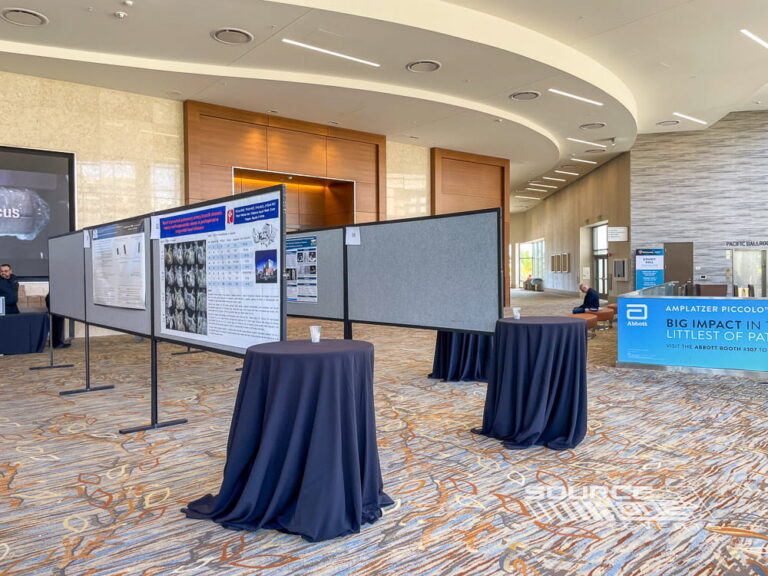 Digital poster presentation displays positioned within a convention center hallway for attendee education and research sharing.