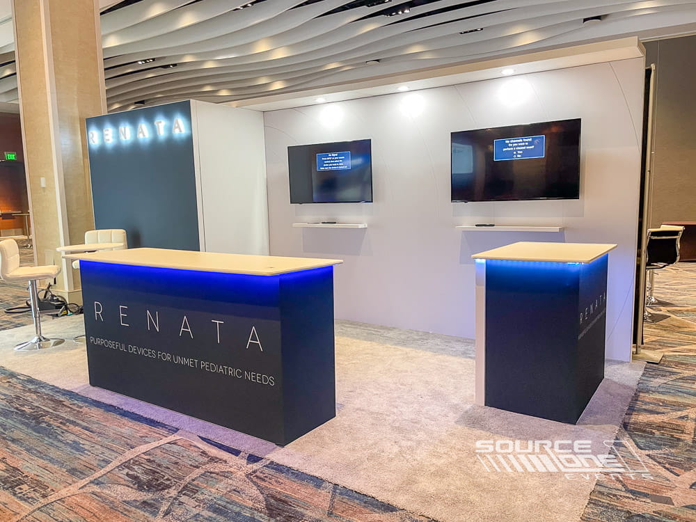 Contemporary exhibit booth featuring clean architectural lines, illuminated branding, and private meeting areas.