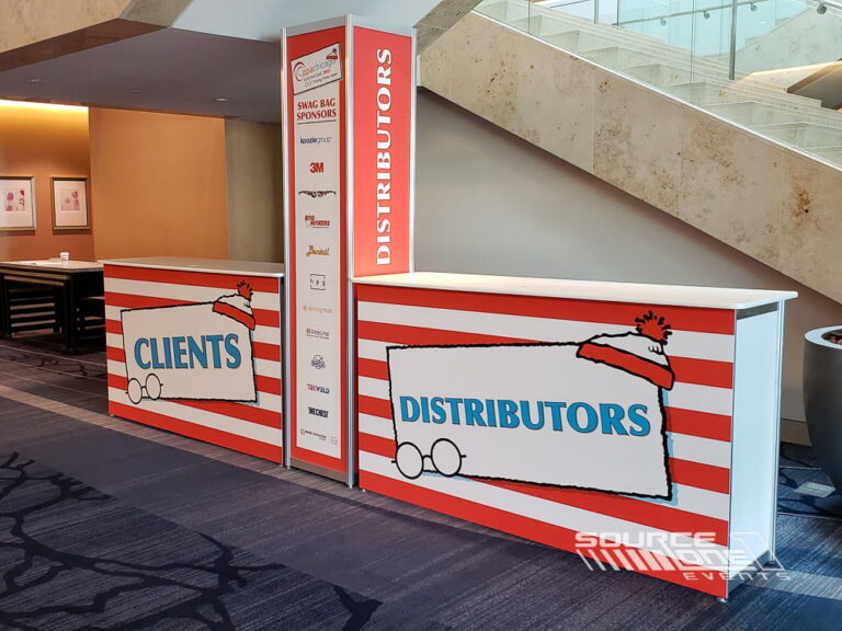 Custom branded registration counters with large-format graphics and wayfinding signage.