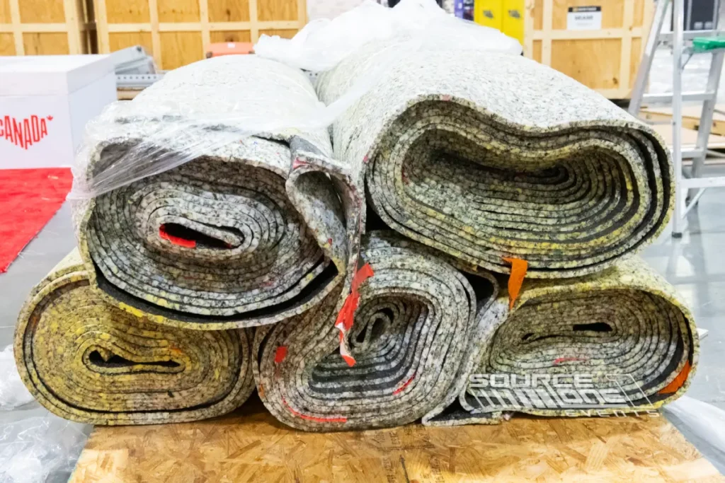 Rolled convention carpets stacked for installation.