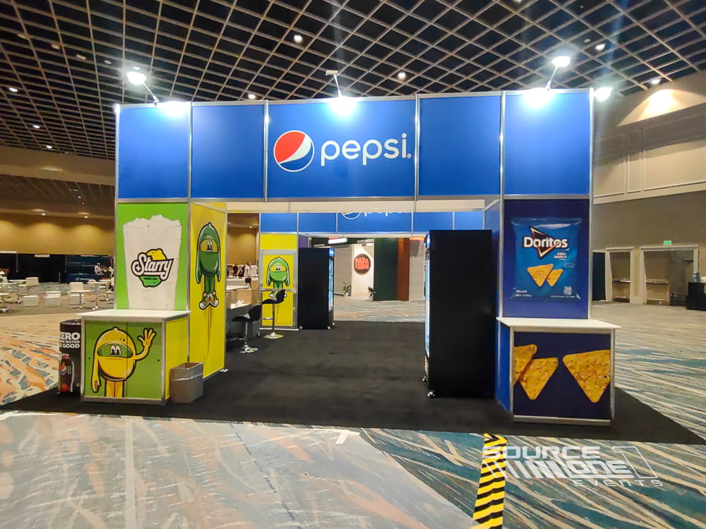 Bright blue Pepsi-branded trade show booth featuring product displays, custom graphics, and promotional engagement space.