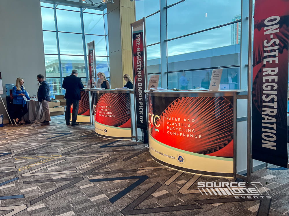 Bright registration area with custom branded counters, informational graphics, and organized attendee check-in stations.