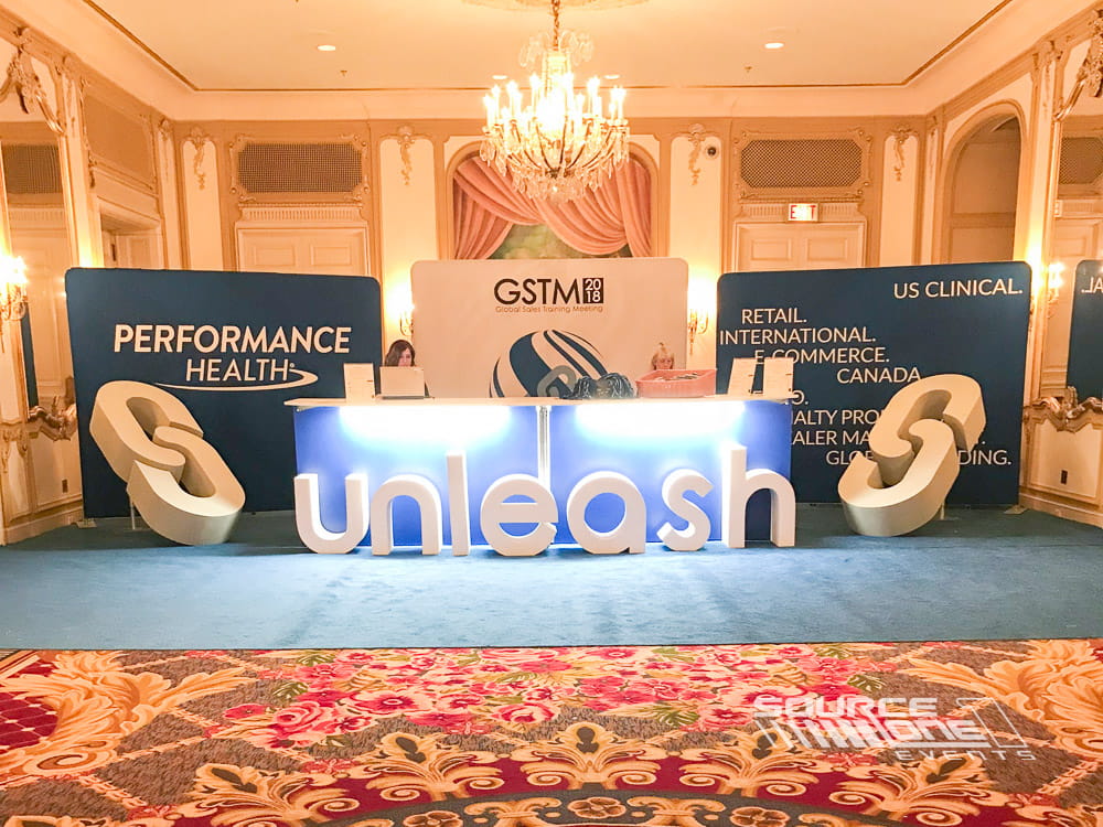 Custom freestanding 3D Performance Health logo displayed during a conference.