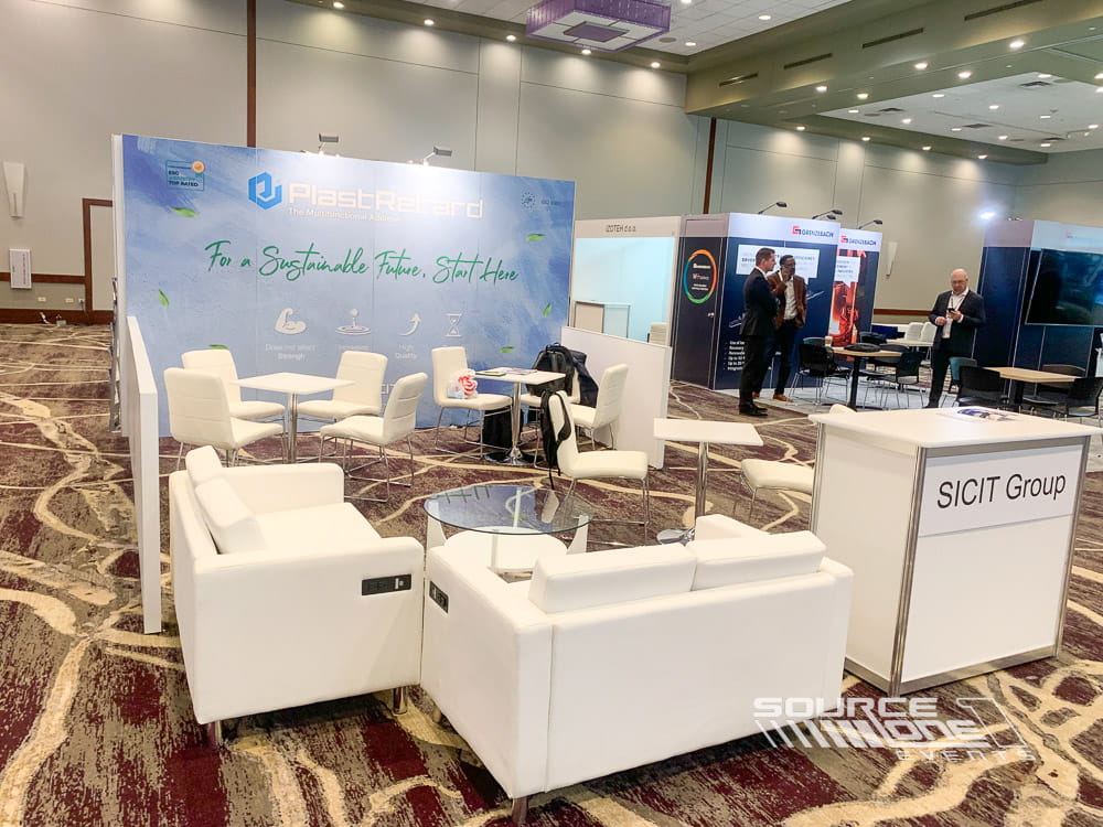 Premium custom exhibit featuring AppDirect branding, LED displays, reception counters, and contemporary architecture.