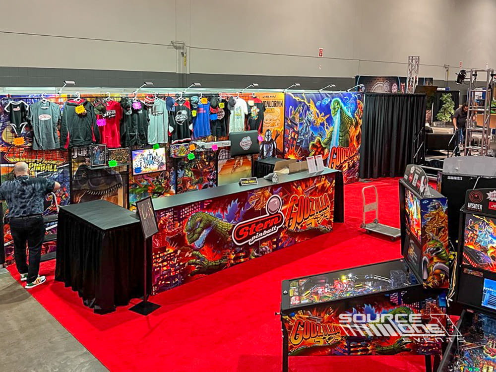 Colorful custom gaming exhibit filled with interactive pinball machines, product displays, and branded graphics.