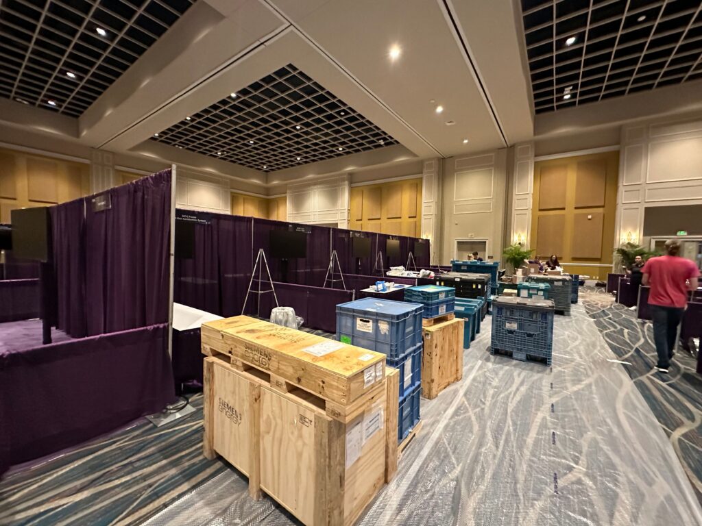 Elegant conference ballroom transformed with pipe and drape staging, premium seating, and professional event production services.