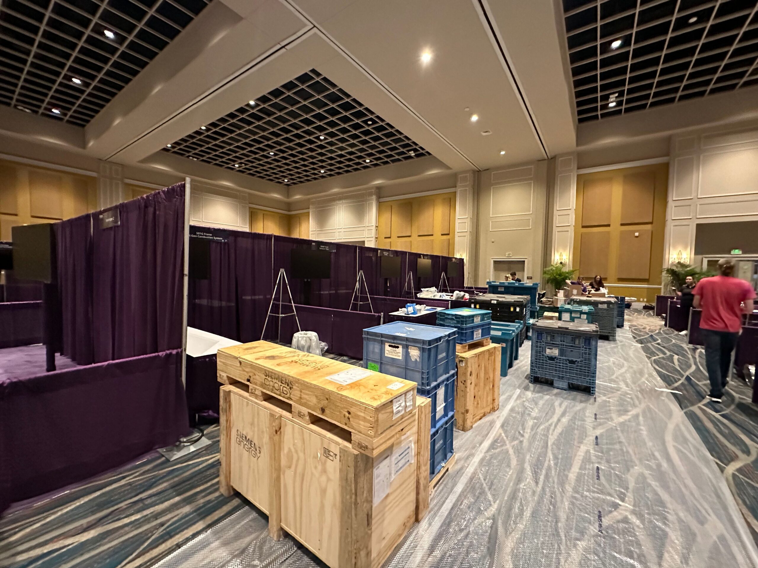 Elegant conference ballroom transformed with pipe and drape staging, premium seating, and professional event production services.