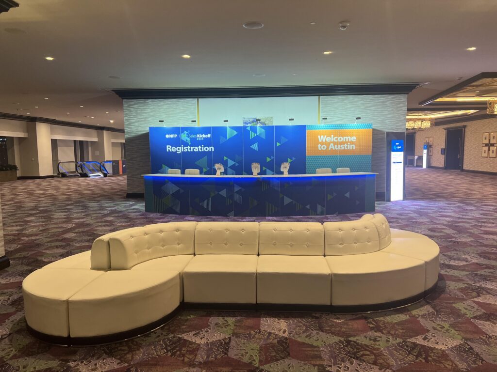 Curved custom seating installation in front of branded conference backdrop