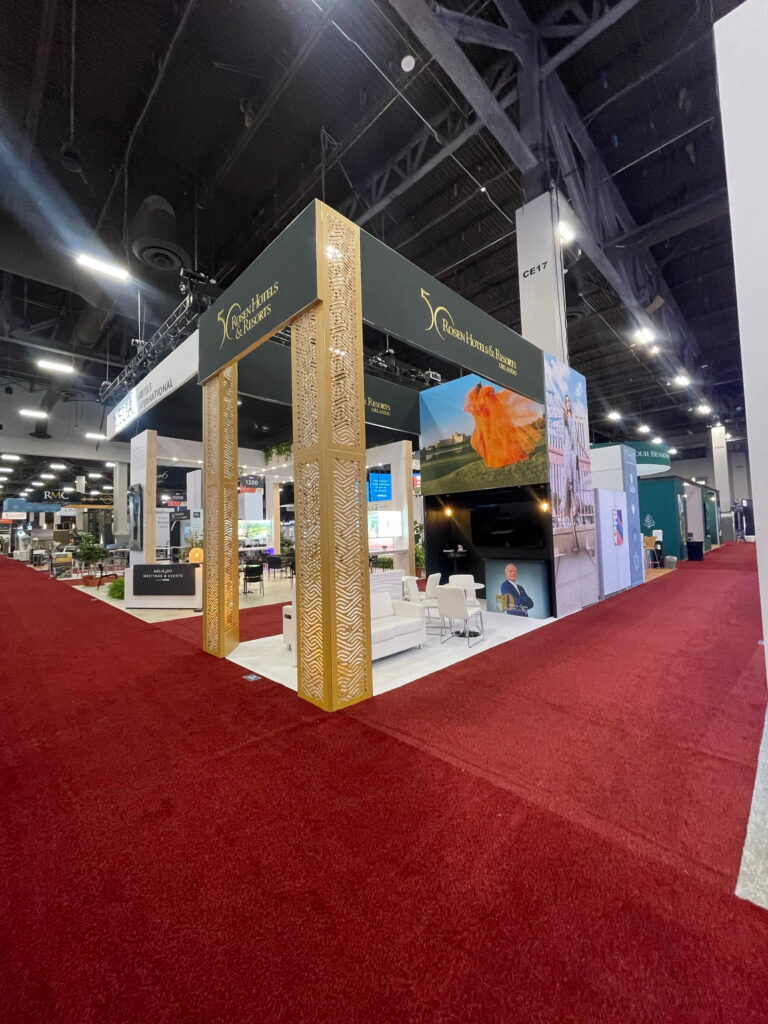 Hospitality exhibit featuring wood architectural elements, open networking space, and premium custom event branding.