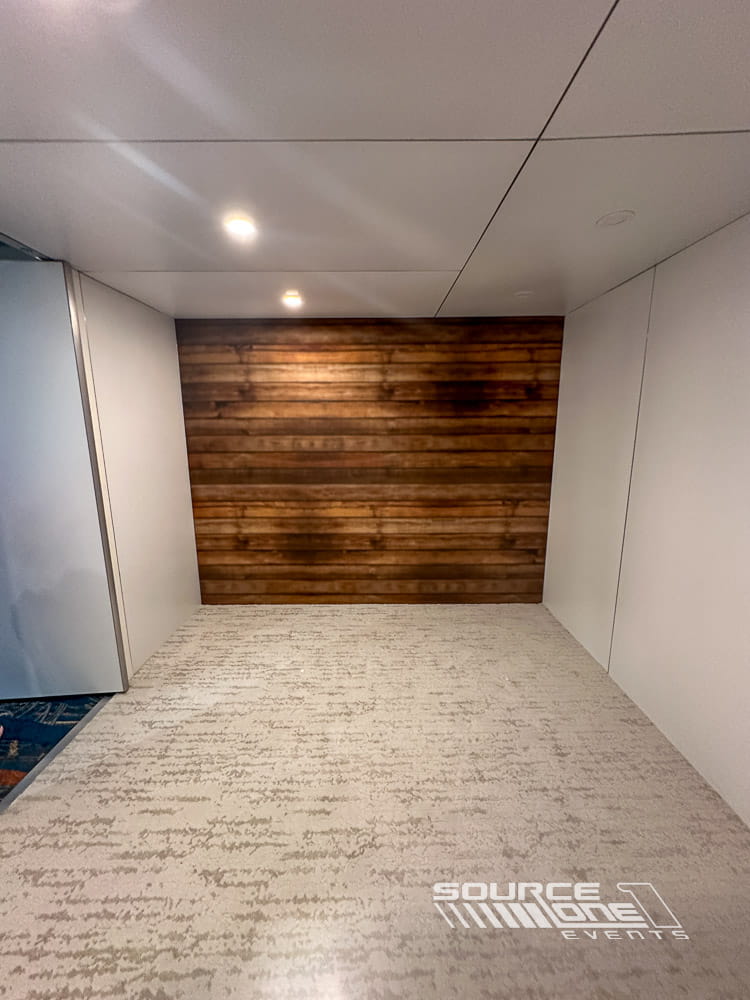 Interior view of a custom branded conference room with wood accent walls, integrated lighting, and premium modular hard-wall construction.