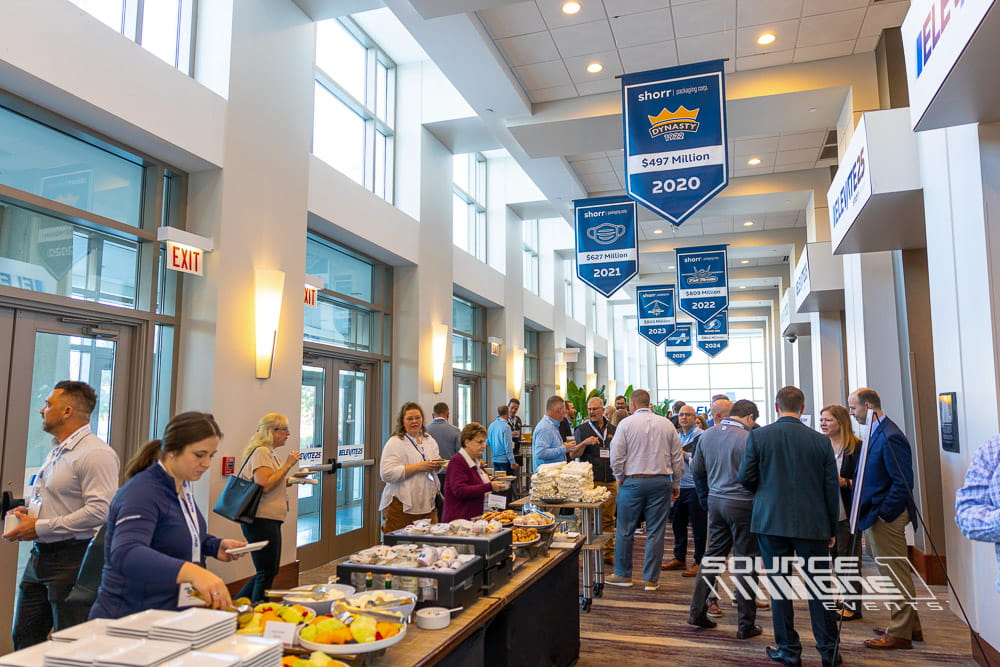 Illuminated conference entrance marquee featuring bold event branding installed above ballroom entry doors.