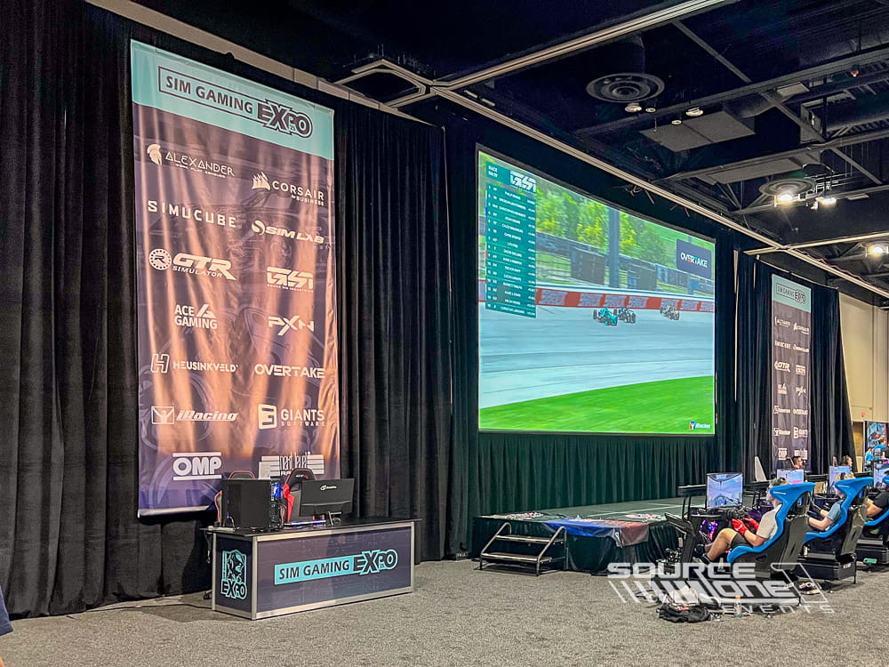 Large overhead conference banner installed across a ballroom entrance featuring branded event graphics and directional messaging.
