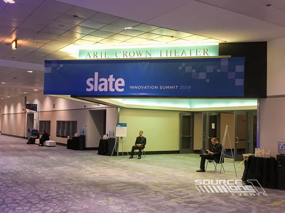 Oversized suspended fabric banner displaying vibrant gaming graphics above the exhibit hall to maximize attendee visibility and wayfinding.