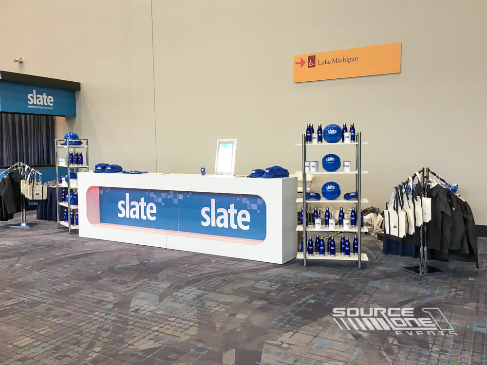 Custom registration and information counters with branded graphics for the Slate event.