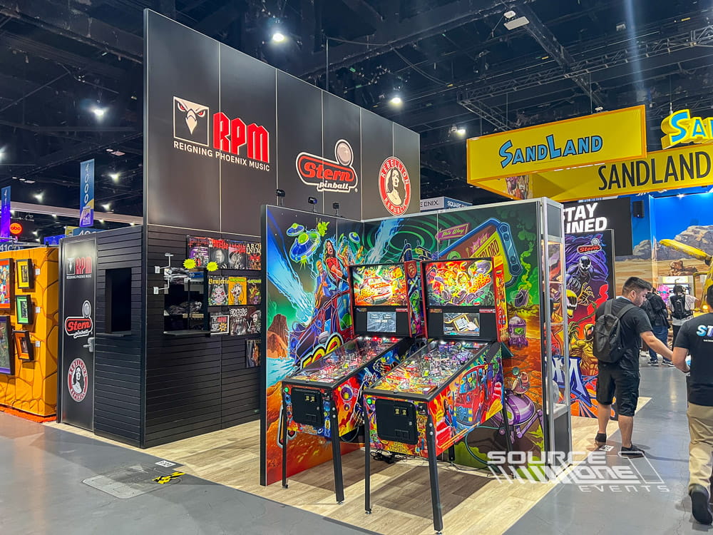 Immersive custom exhibit featuring colorful gaming graphics, interactive pinball machines, and branded entertainment experiences.